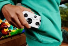 يد تحكم Xbox Nano البيضاء في جيب لاعب أمام شاشة ألعاب