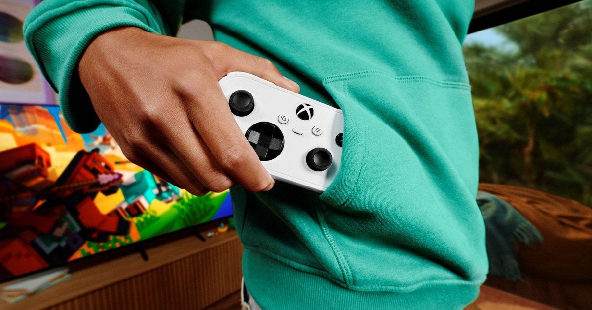 يد تحكم Xbox Nano البيضاء في جيب لاعب أمام شاشة ألعاب