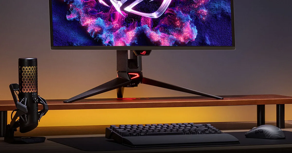 مونيتور ألعاب ASUS ROG على مكتب مع لوحة مفاتيح وماوس وإضاءة خلفية زرقاء
